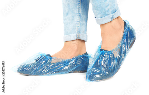 Fototapeta Naklejka Na Ścianę i Meble -  Woman with blue shoe covers worn over loafers on white background, closeup
