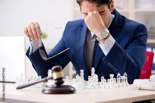 Young lawyer playing chess to train his court strategy and tacti photo