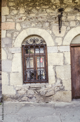 The window is framed by a stone arch with wrought-iron bar  on the Sharambeyan street in the Museum Tufenkian Old Dilijan  