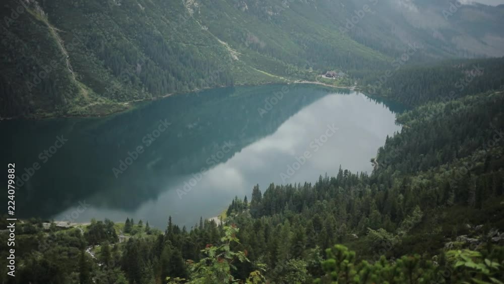Amazing beautiful blue mountain lake with green forest and high mountains in the background Morskie Oko - Poland europe hill landscape nature peak rock sky tatra close up slow motion Amazing beautiful blue mountain lake with green forest and high mountains in the background Morskie Oko - Poland europe hill landscape nature peak rock sky tatra close up slow motion