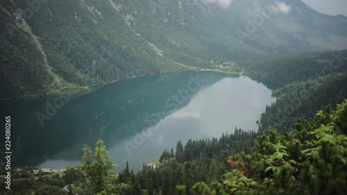 Amazing beautiful blue mountain lake with green forest and high mountains in the background Morskie Oko - Poland europe hill landscape nature peak rock sky tatra close up slow motion