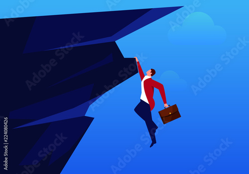 Businessman hanging on a cliff