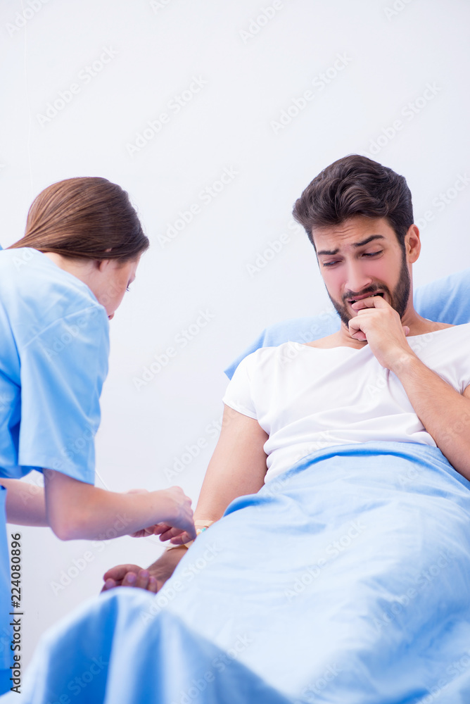 Woman doctor examining male patient in hospital Woman doctor examining male patient in hospital