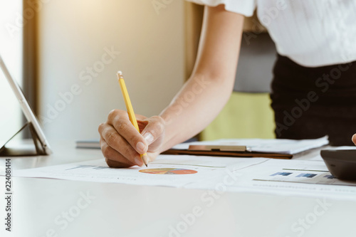 Businesswoman working with financial data and using calculator and writing make note with calculate.Business financial and accounting concept.