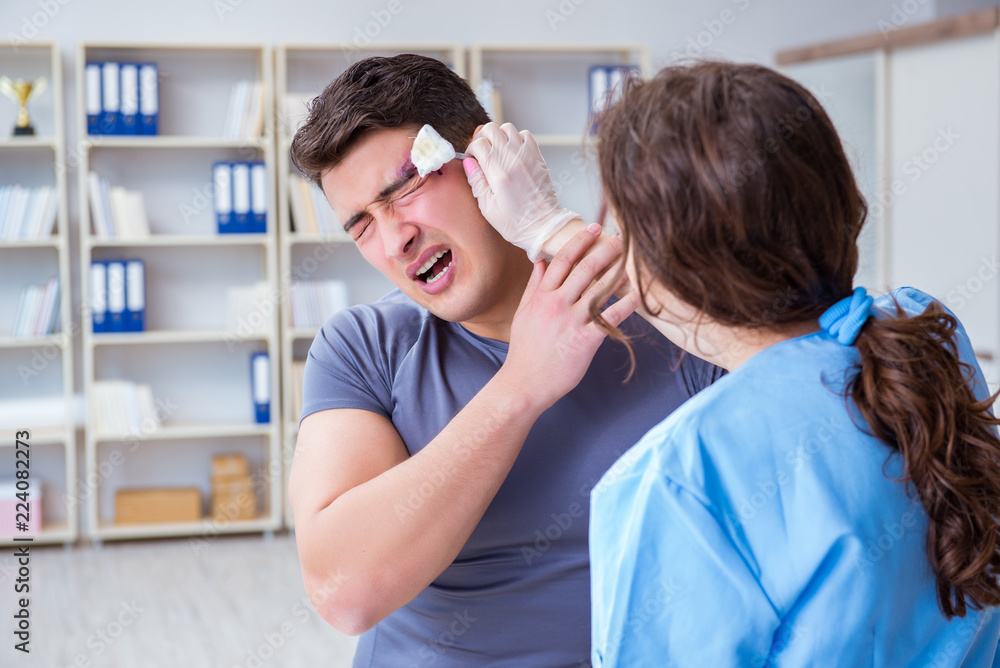 Young man visiting female traumatologist with black eye Young man visiting female traumatologist with black eye