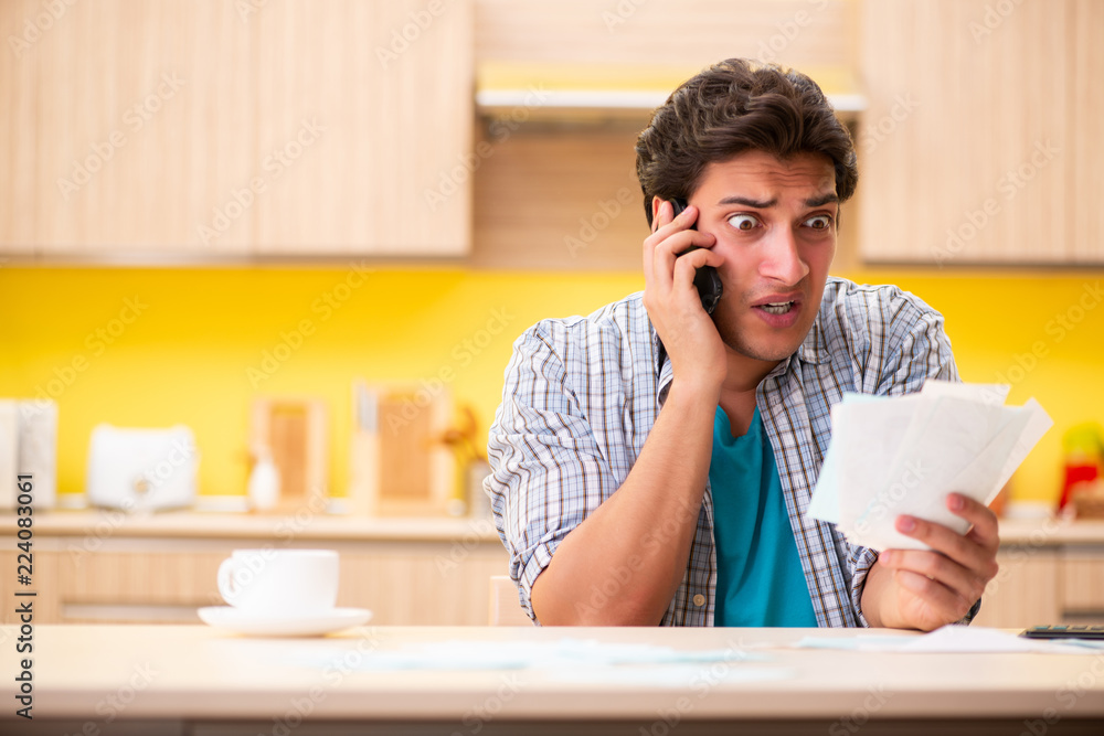 Young man husband in budget planning concept Young man husband in budget planning concept