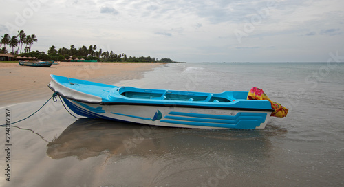 Blue fishing boat on tropical beach Nilaveli beach in Sri Lanka Asia