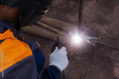 Operator welding steel construction. Industrial worker during welding works