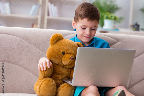 Little boy surfing internet on laptop