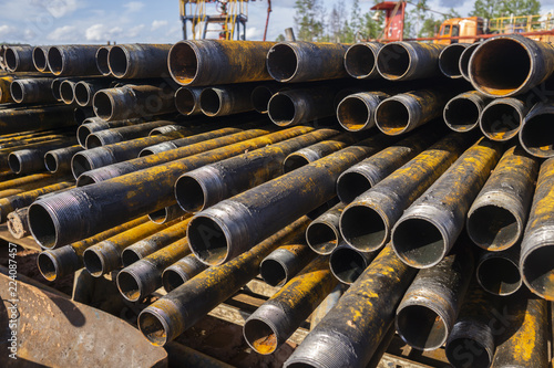 Drilling of oil and gas wells. Drill pipe inspection. Tubing for oil and gas listed on the pedestal out of the wells after washing and ready for inspection. Stack of casing laying on the deck photo