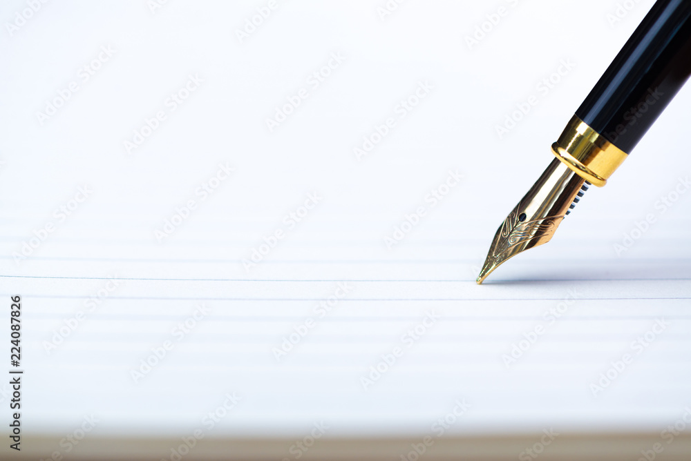 Close up of fountain pen or ink pen with notebook paper on wooden working table with copy space, office desk concept. shallow focus. Close up of fountain pen or ink pen with notebook paper on wooden working table with copy space, office desk concept. shallow focus.