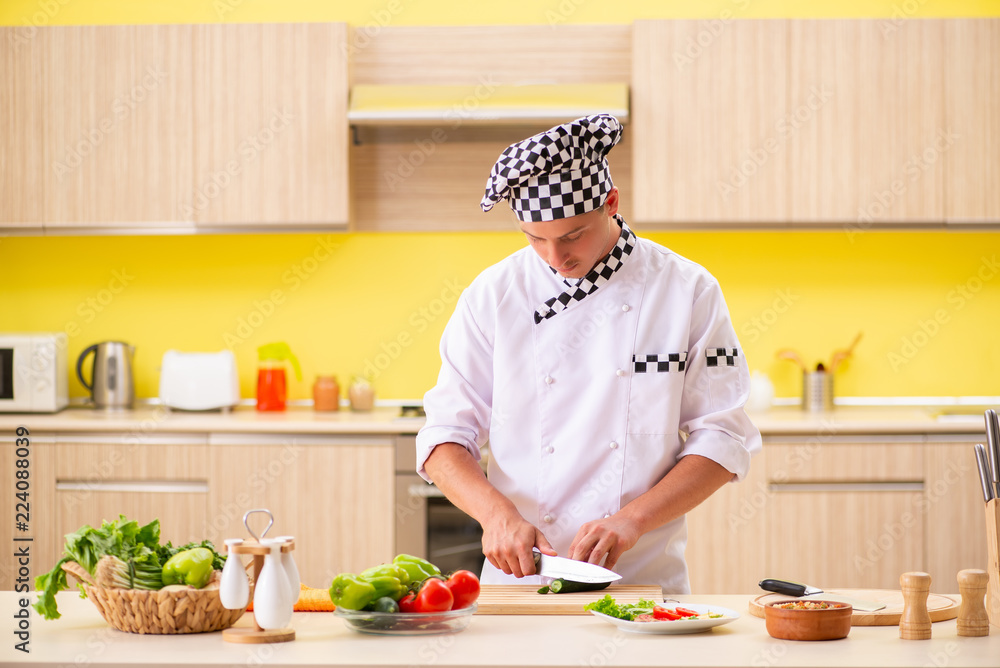 Young professional cook preparing salad at kitchen Young professional cook preparing salad at kitchen