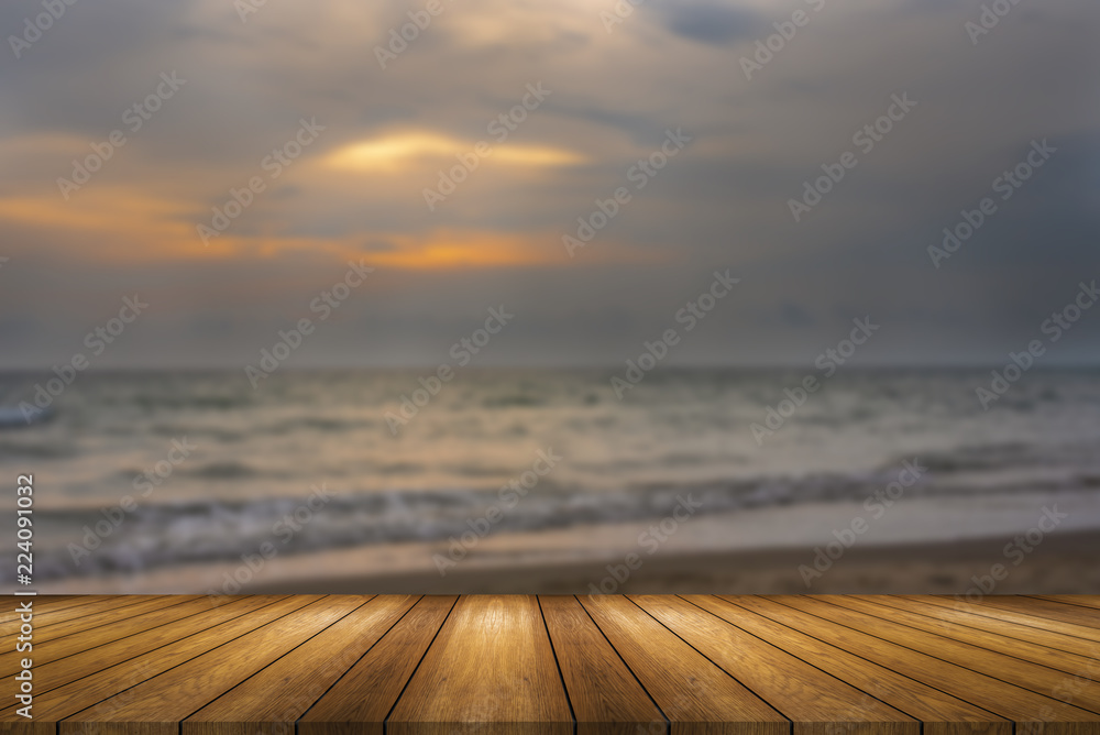 Wooden board empty table and blurred or defocus background and light bulb bokeh . Perspective brown wood table over blur in sunset beach background , this image in background or backdrop concept