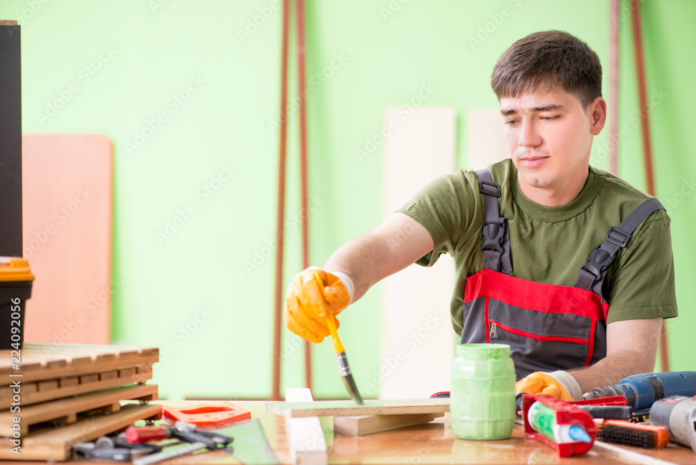 Young man carpenter working in workshop Young man carpenter working in workshop