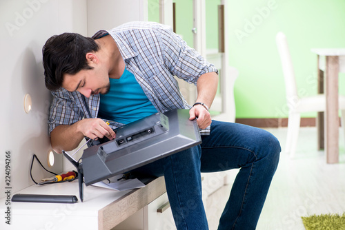 Φωτογραφία Young man husband repairing tv at home