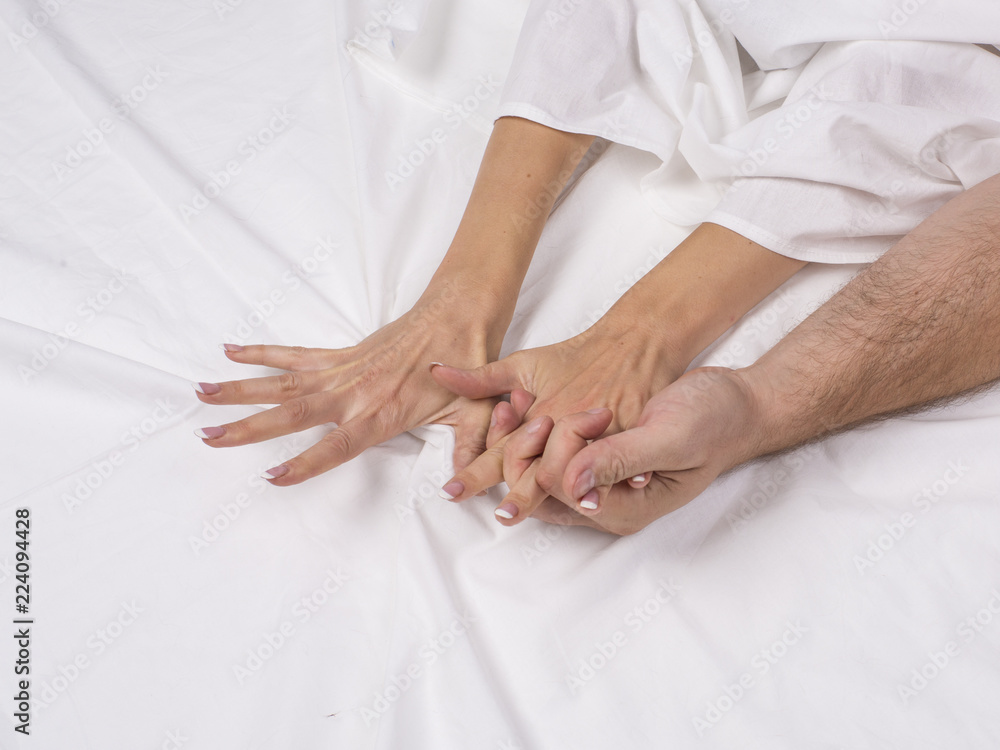 Couple making love in bed - focus on hands. Couple making love in bed - focus on hands.