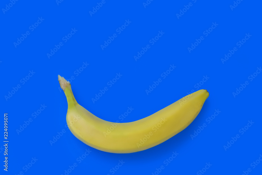one yellow banana lies on a blue background one yellow banana lies on a blue background