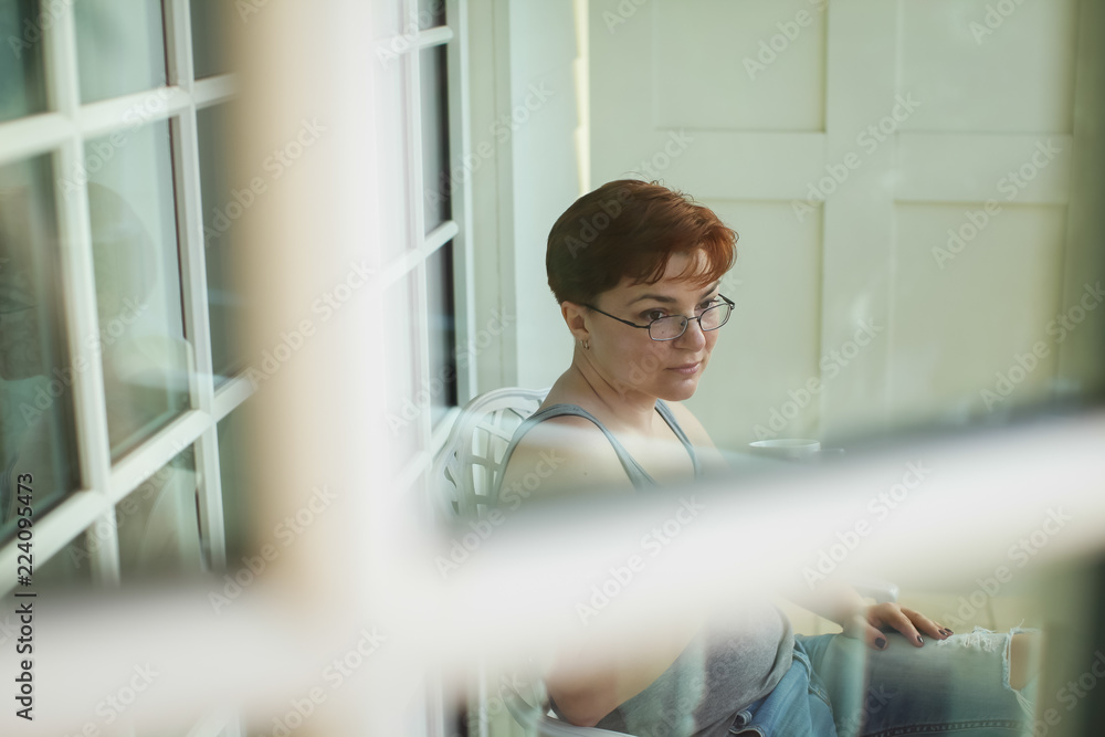 Woman relaxing on balcony holding cup of coffee or tea Woman relaxing on balcony holding cup of coffee or tea