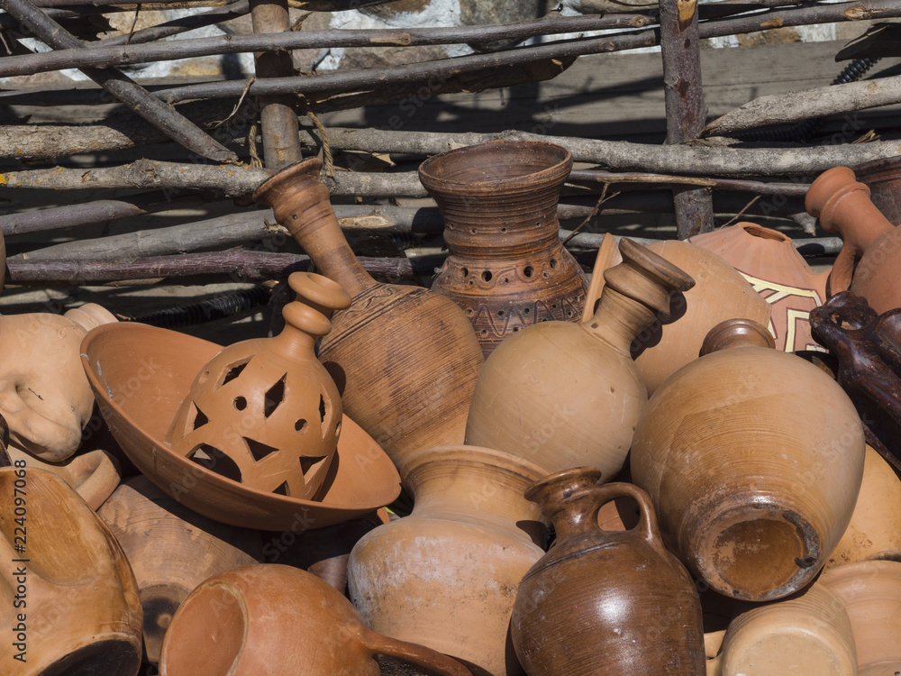 a lot of pottery on the table. different ceramic vases and pots
