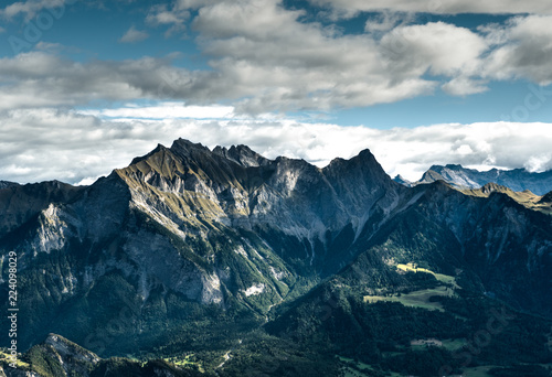 mountain landscape in the Swiss Alps above Maienfeld with many peaks and forests and valleys below in early autumn  photo