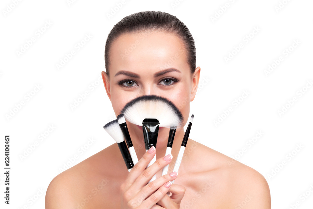 Pretty woman holds cosmetics makeup brushes, isolated on white background Pretty woman holds cosmetics makeup brushes, isolated on white background