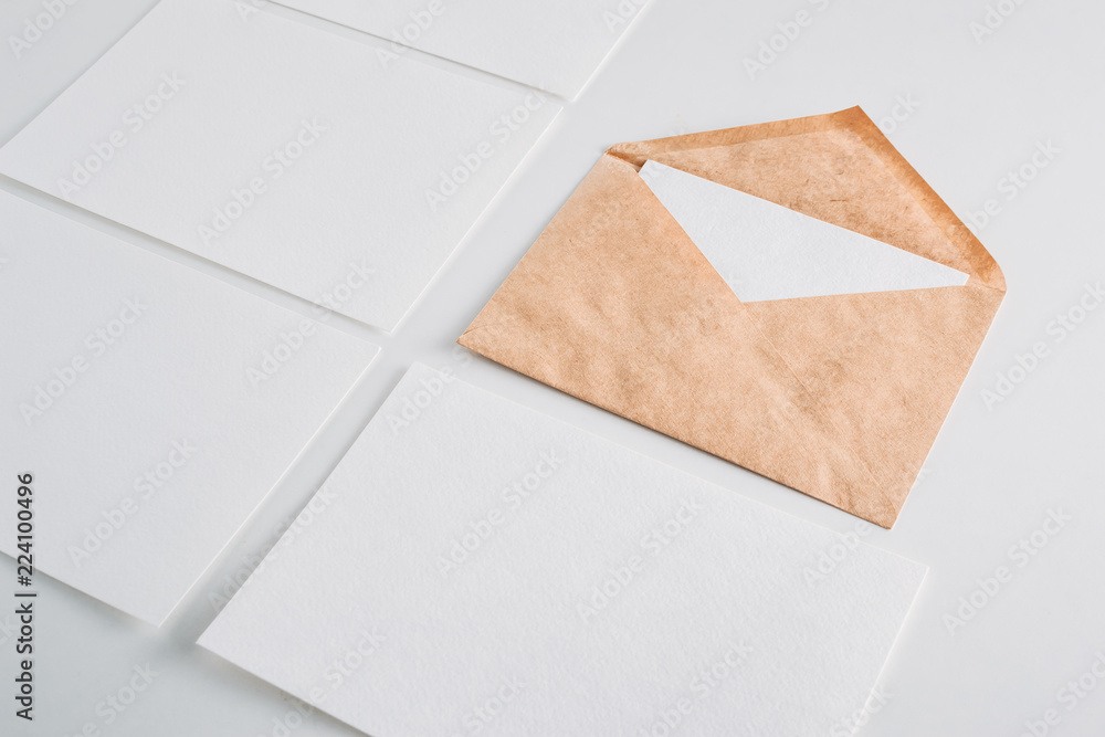 White paper empty sheets cards and kraft envelope on a white background. Mockup for design White paper empty sheets cards and kraft envelope on a white background. Mockup for design