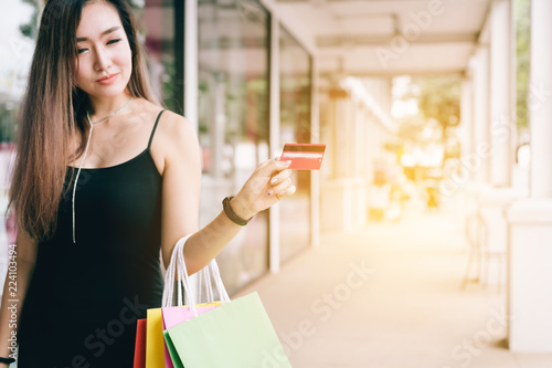 Beautiful asian woman holding credit card at the shopping mall.