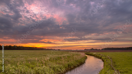 Sunrise over broad river valley landscape