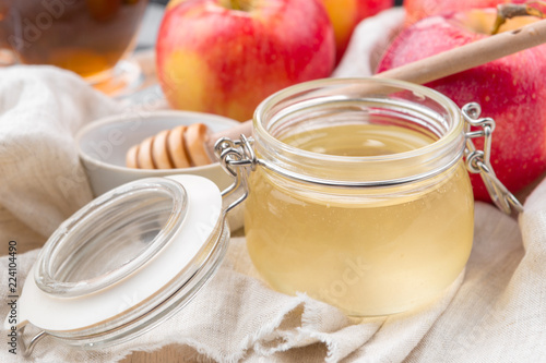 Jewish holiday Rosh Hashanah background with honey and apples on wooden table.