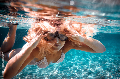Beautiful woman with long hair underwater portrait in the tropical sea