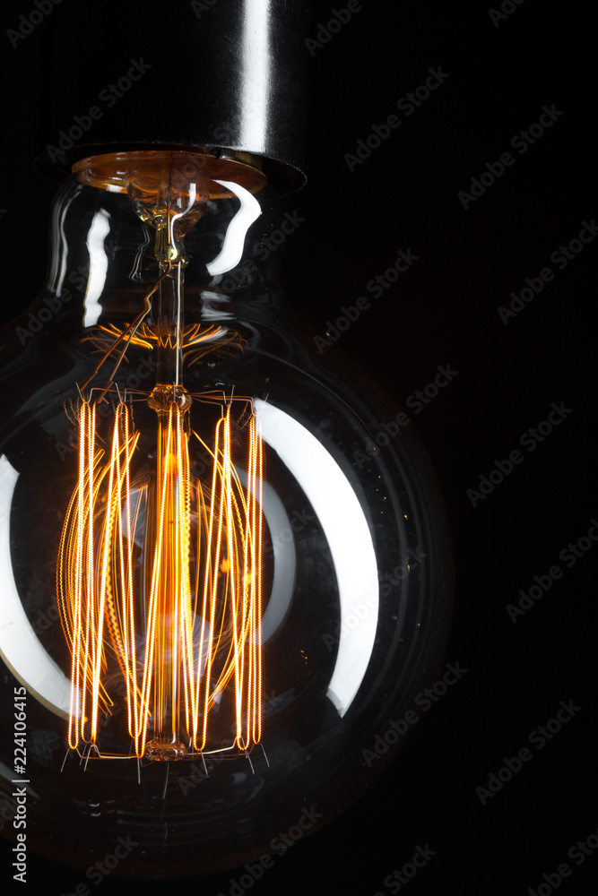 A classic Edison light bulb on dark background with space for text