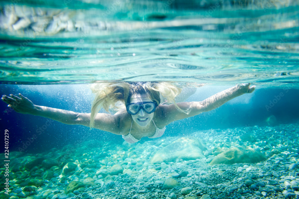 Snorkeling in the tropical sea, woman with mask diving underwater