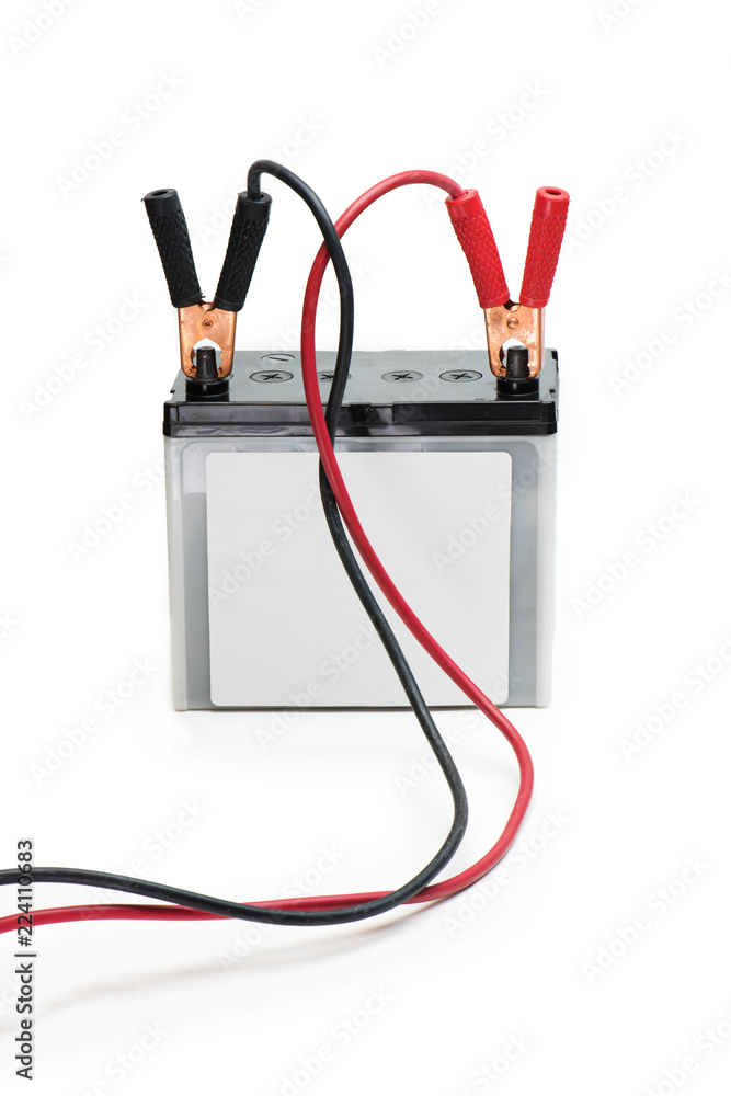 A Car battery with red and black battery Jumper or booster cables with copper clamps attached to the terminals. Automotive battery isolated on white.