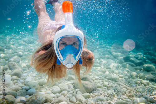 Woman snorkeling with full face mask in the tropical sea