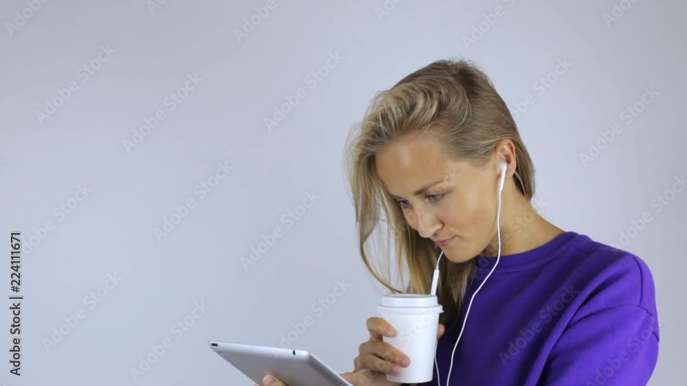Girl drinks coffee and uses a tablet Girl drinks coffee and uses a tablet