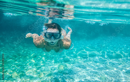 Woman with mask underwater snorkeling in the clear tropical water