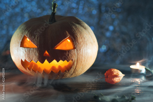 Scary laughing pumpkin lantern on dark background with copy space photo