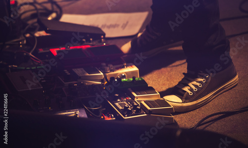 Electric guitar players legs on a stage photo