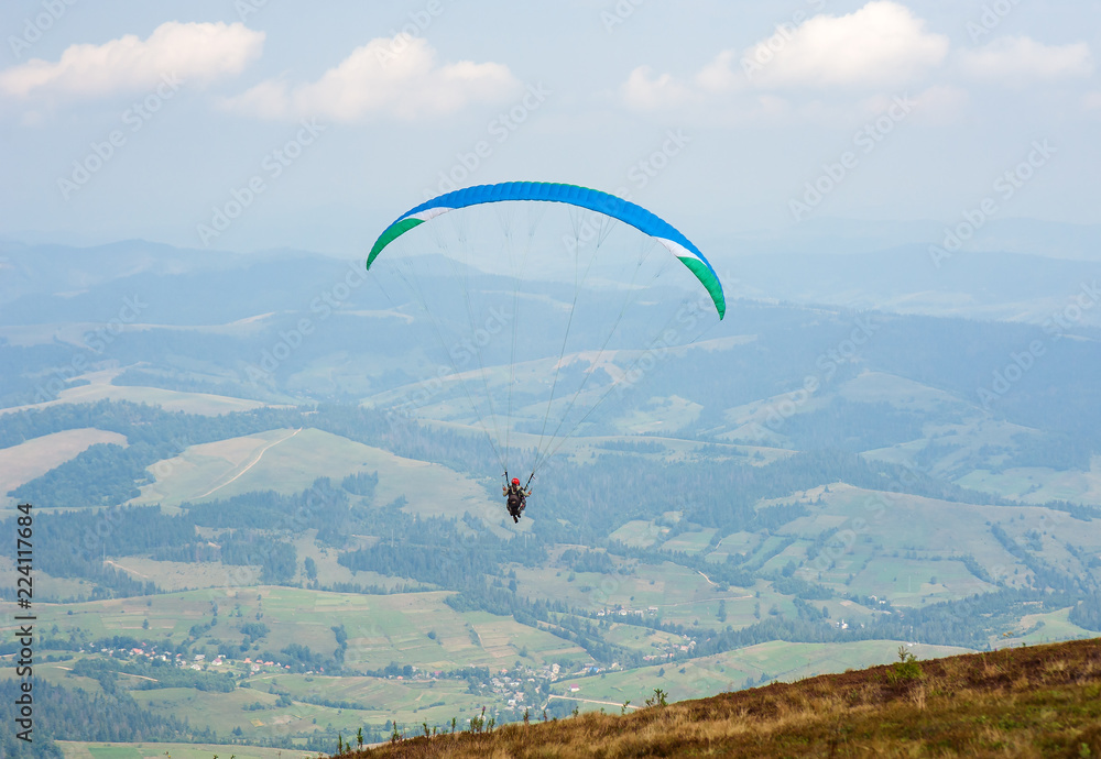 Paraglider takes off from the mountainside in the Carpathian Mountains. Paragliding in the mountains in the summer. Paraglider takes off from the mountainside in the Carpathian Mountains. Paragliding in the mountains in the summer.