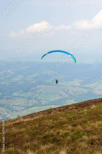 Paraglider takes off from the mountainside in the Carpathian Mountains. Paragliding in the mountains in the summer.