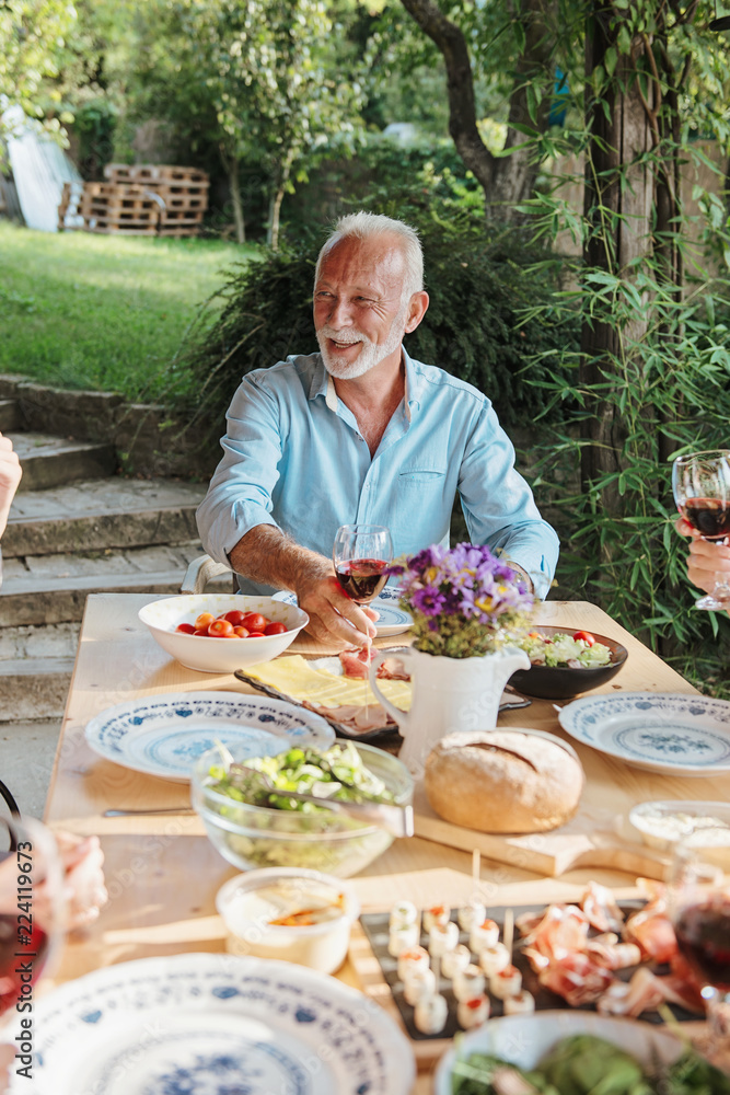 Family cheering over the dining table outdoors, celebration Family cheering over the dining table outdoors, celebration