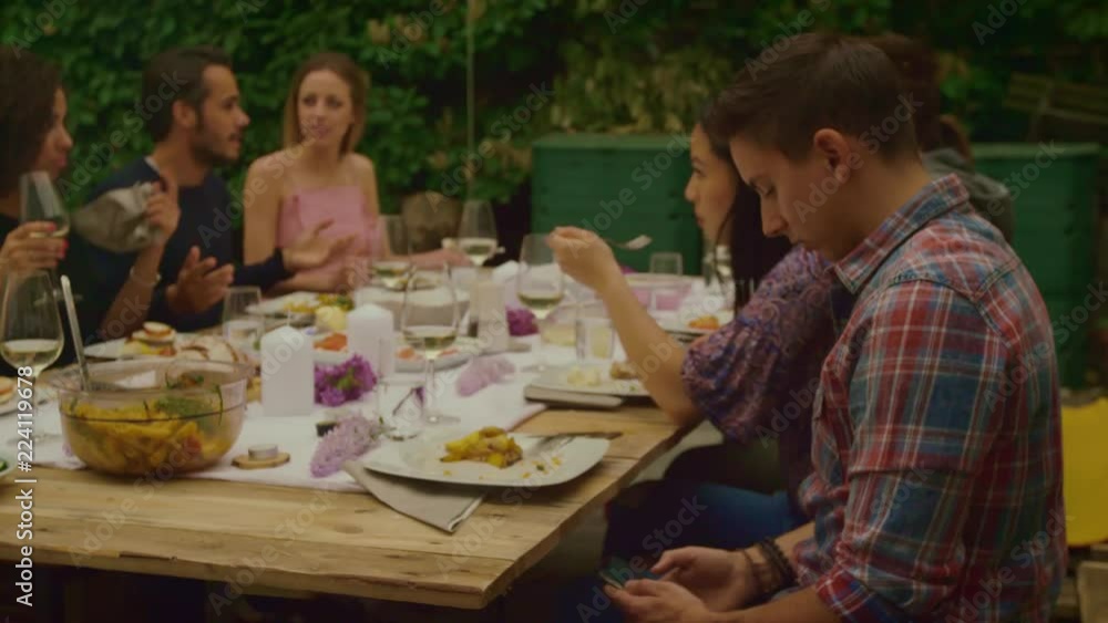 Man is on phone while dinner party outside Man is on phone while dinner party outside