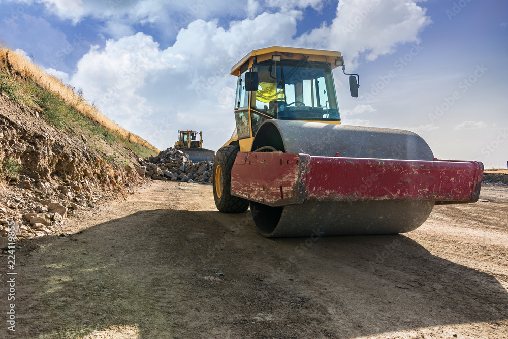Construction of a road with heavy machinery using a roller and an excavator Construction of a road with heavy machinery using a roller and an excavator