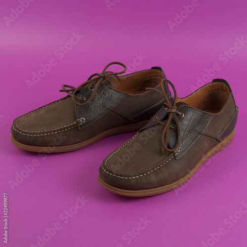 Men's brown moccasins, loafers isolated on pink background.