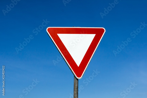 Yield give way sign on a blue sky background