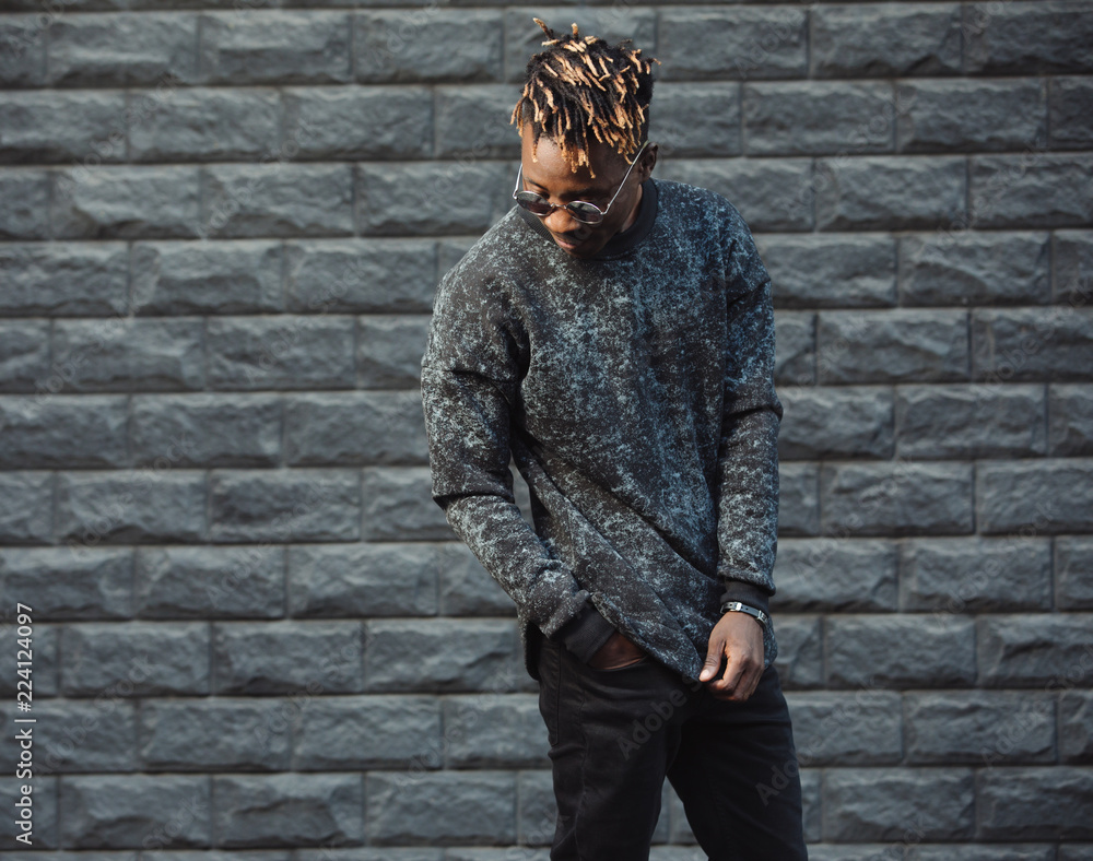 Obraz premium African american man model wear stylish fashionable pullover standing against brick wall