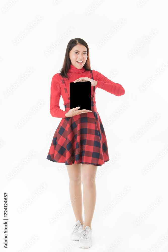 Beautiful Asain portrait woman in red casual dress standing smiling holding tablet in hand blank space isolated on white background Beautiful Asain portrait woman in red casual dress standing smiling holding tablet in hand blank space isolated on white background