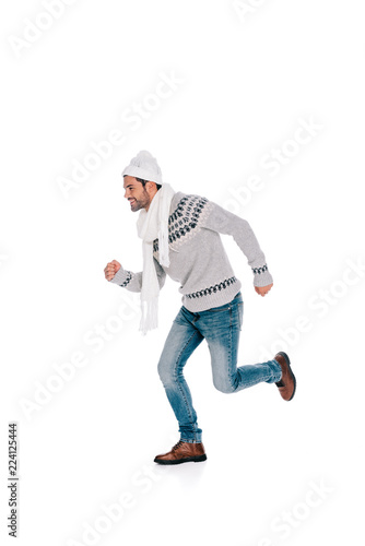 smiling young man in sweater, scarf and hat running and looking away isolated on white © LIGHTFIELD STUDIOS