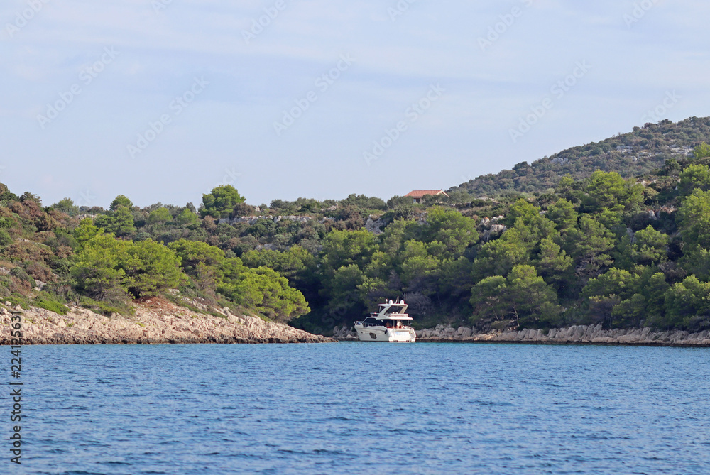 A luxury motor yacht hid in the cove of Dalmatia island in Croatia. Active rest on the Adriatic Sea of the Mediterranean region. Prestigious and rich lifestyle. Sea tourism far from civilization A luxury motor yacht hid in the cove of Dalmatia island in Croatia. Active rest on the Adriatic Sea of the Mediterranean region. Prestigious and rich lifestyle. Sea tourism far from civilization