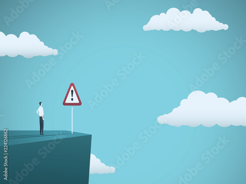 Business risk vector concept. Businessman standing on the edge of cliff with warning sign. Symbol of danger, failure, bankruptcy, recession and crisis.